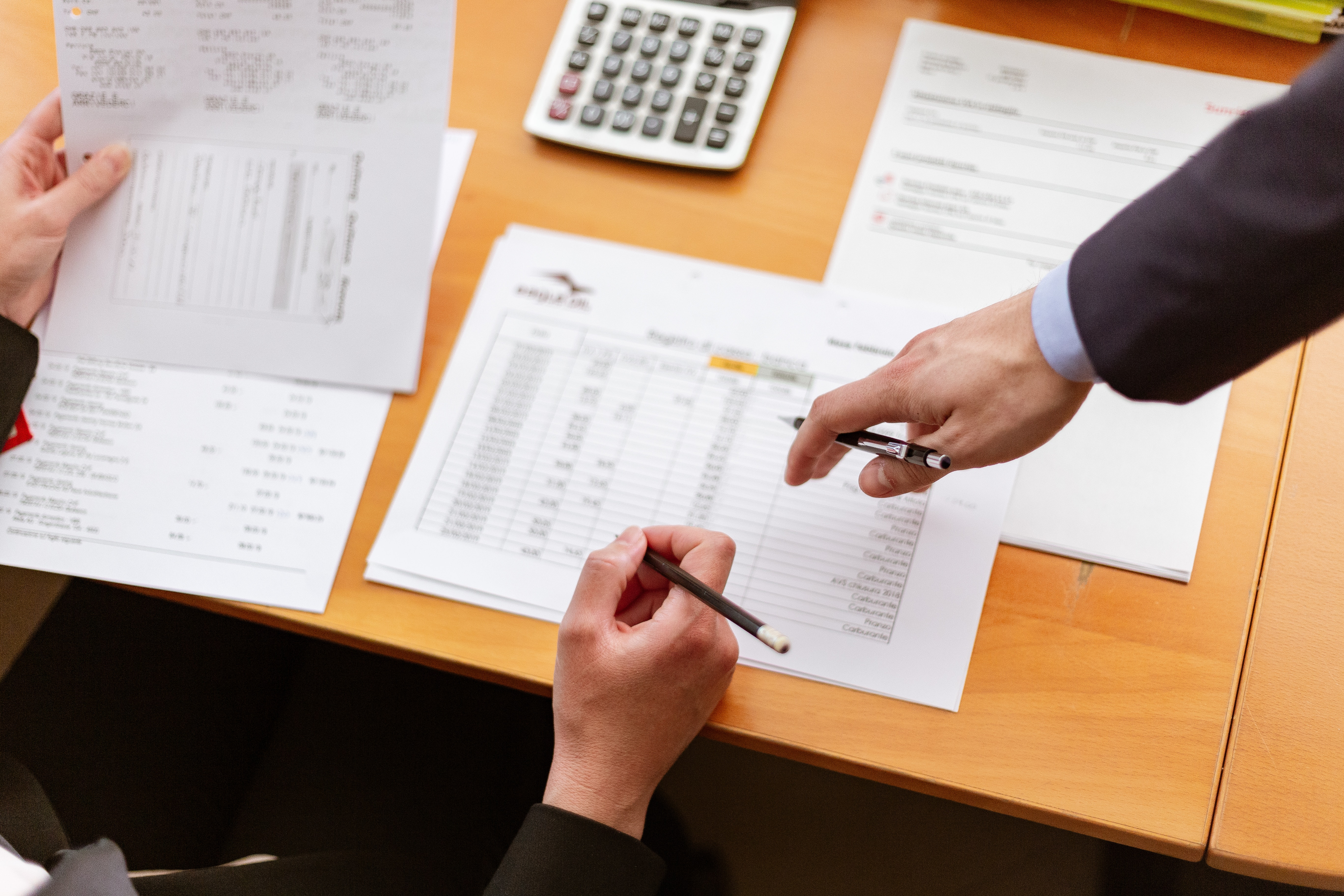 A stock image of two people (off screen) reviewing paperwork